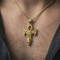 Load image into Gallery viewer, Gold plated Eye of Horus ankh pendant necklace worn on the neck, captured on a human model in a premium dark-toned lifestyle frame.
