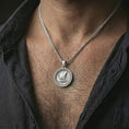 Load image into Gallery viewer, Polished silver Viking ship pendant necklace worn on the neck, shown against the chest in a clean and adventurous everyday wear composition.
