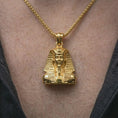 Load image into Gallery viewer, Gold plated Tutankhamun pendant necklace worn on the neck, captured on a human model in a premium dark-toned lifestyle frame.
