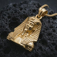 Load image into Gallery viewer, Gold plated Tutankhamun pendant necklace presented on porous volcanic rock, highlighting the iconic Egyptian king bust in a luxurious close-up jewelry image.

