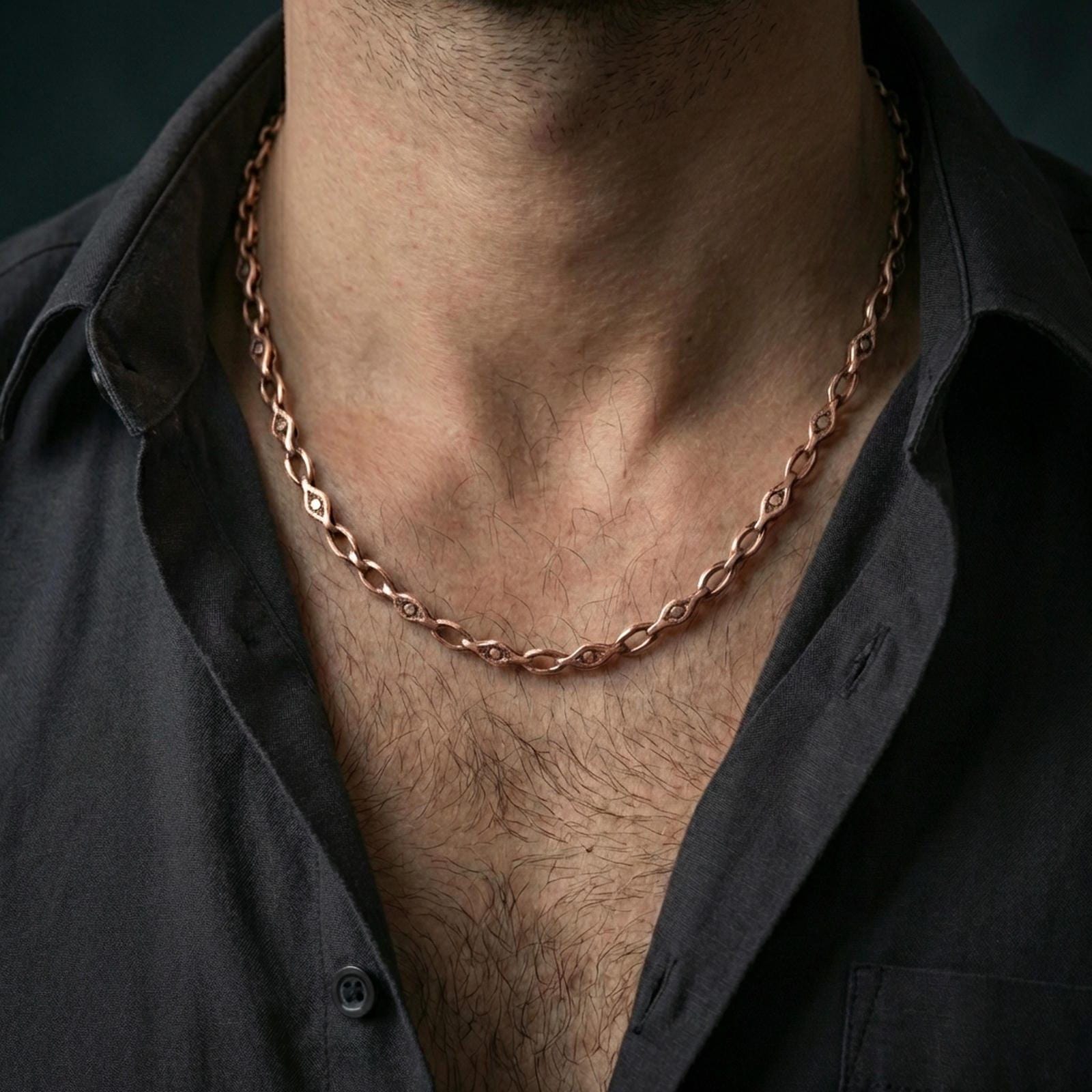 Rose gold plated evil eye link chain necklace worn on the neck, presented in a close-up lifestyle shot with a refined masculine aesthetic.