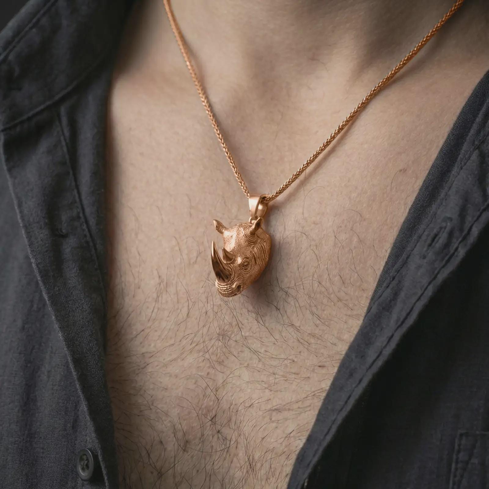 Rose gold plated rhinoceros head pendant necklace worn on the neck, presented in a close-up lifestyle shot with a refined wildlife-inspired aesthetic.