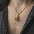 Load image into Gallery viewer, Gold plated rhinoceros head pendant necklace worn on the neck, captured on a human model in a premium dark-toned lifestyle frame.
