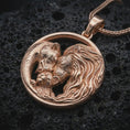 Load image into Gallery viewer, Rose gold plated lion and bear family pendant necklace on dark volcanic rock, photographed in a detailed premium studio macro view.
