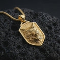 Load image into Gallery viewer, Gold plated ferocious wolf shield pendant necklace presented on porous volcanic rock, highlighting the savage beast totem design in a luxurious close-up jewelry image.
