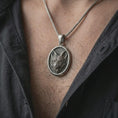 Load image into Gallery viewer, Oxidized fox medallion pendant necklace worn on the neck, styled in a dark lifestyle portrait with an open shirt and elegant nature-inspired presentation.
