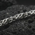 Load image into Gallery viewer, Polished silver DNA helix chain necklace displayed on black volcanic rock, shown in a refined macro product shot with interlocking molecular links and clean scientific design.
