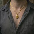 Load image into Gallery viewer, Gold plated roaring lion shield pendant necklace worn on the neck, captured on a human model in a premium dark-toned lifestyle frame.

