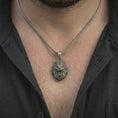 Load image into Gallery viewer, Oxidized crowned lion head pendant necklace worn on the neck, styled in a dark lifestyle portrait with an open shirt and bold royal presentation.

