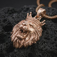 Load image into Gallery viewer, Rose gold plated crowned lion head pendant necklace on dark volcanic rock, photographed in a detailed premium studio macro view.
