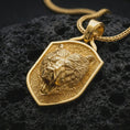Load image into Gallery viewer, Gold plated roaring bear shield pendant necklace presented on porous volcanic rock, highlighting the fierce Norse-inspired bear motif in a luxurious close-up jewelry image.
