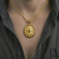 Load image into Gallery viewer, Gold plated lion medallion pendant necklace worn on the neck, captured on a human model in a premium dark-toned lifestyle frame.
