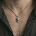 Load image into Gallery viewer, Polished silver wolf head pendant necklace worn on the neck, shown against the chest in a clean and striking everyday wear composition.

