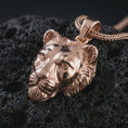 Load image into Gallery viewer, Rose gold plated 3D lioness pendant necklace on dark volcanic rock, photographed in a detailed premium studio macro view.
