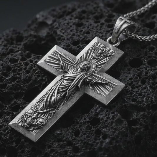 Sterling silver Jesus Ascension cross pendant necklace with an oxidized finish resting on textured volcanic rock, captured in a close-up premium studio composition.