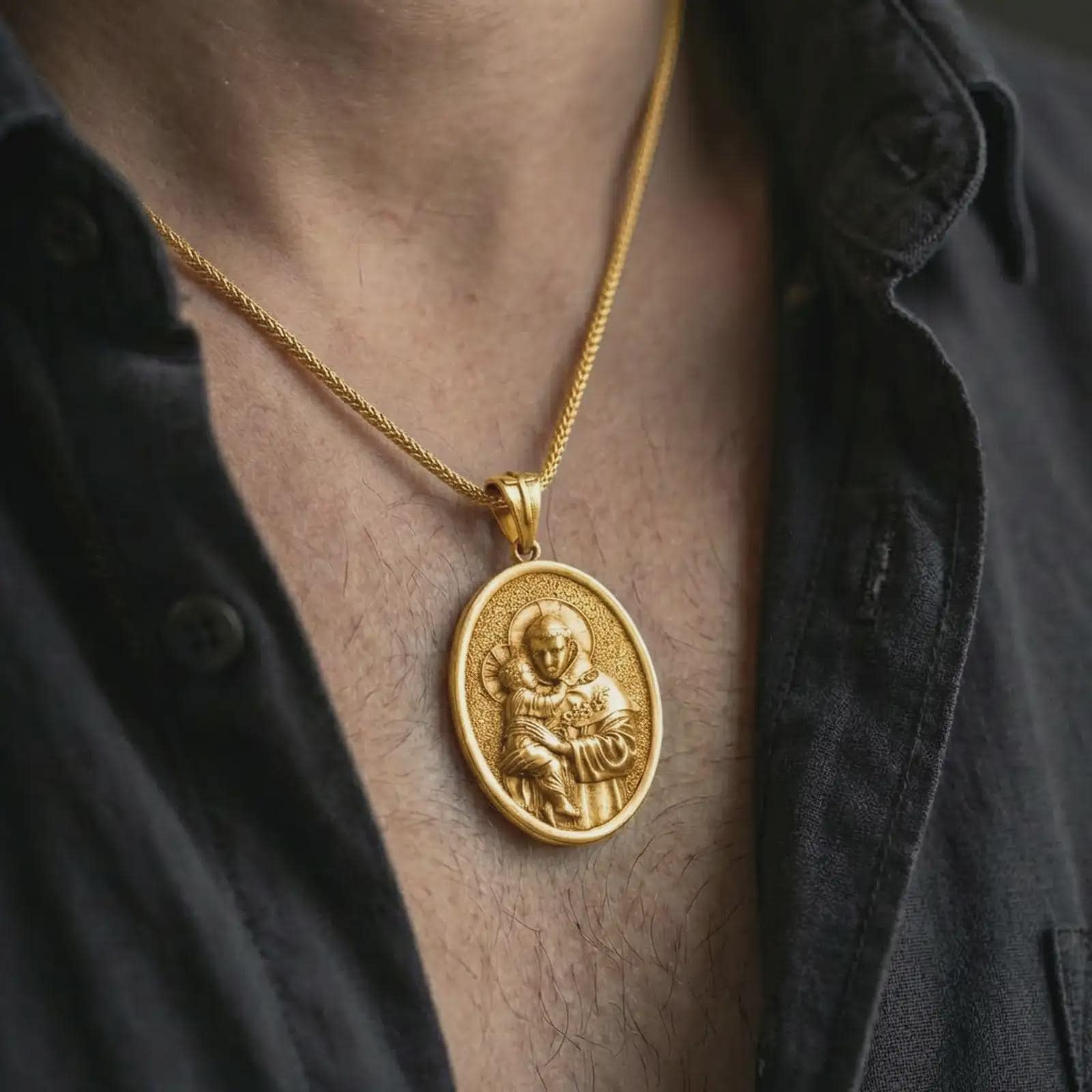 Gold plated Saint Anthony pendant necklace worn on the neck, captured on a human model in a premium dark-toned lifestyle frame.