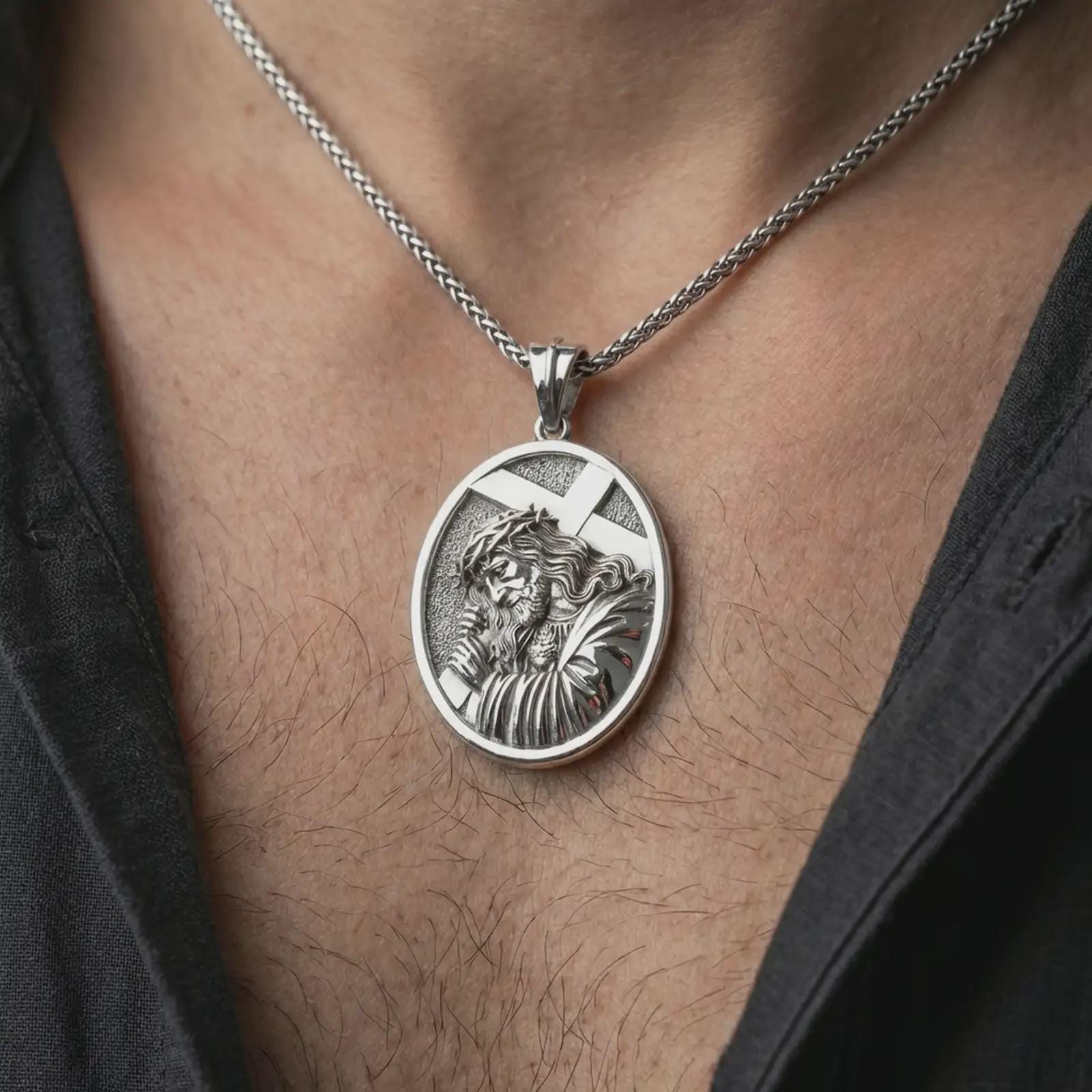 Polished silver Jesus carrying cross pendant necklace worn on the neck, shown against the chest in a clean and elegant everyday wear composition.