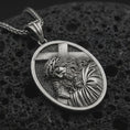 Load image into Gallery viewer, Sterling silver Jesus carrying cross pendant necklace with an oxidized finish resting on textured volcanic rock, captured in a close-up premium studio composition.
