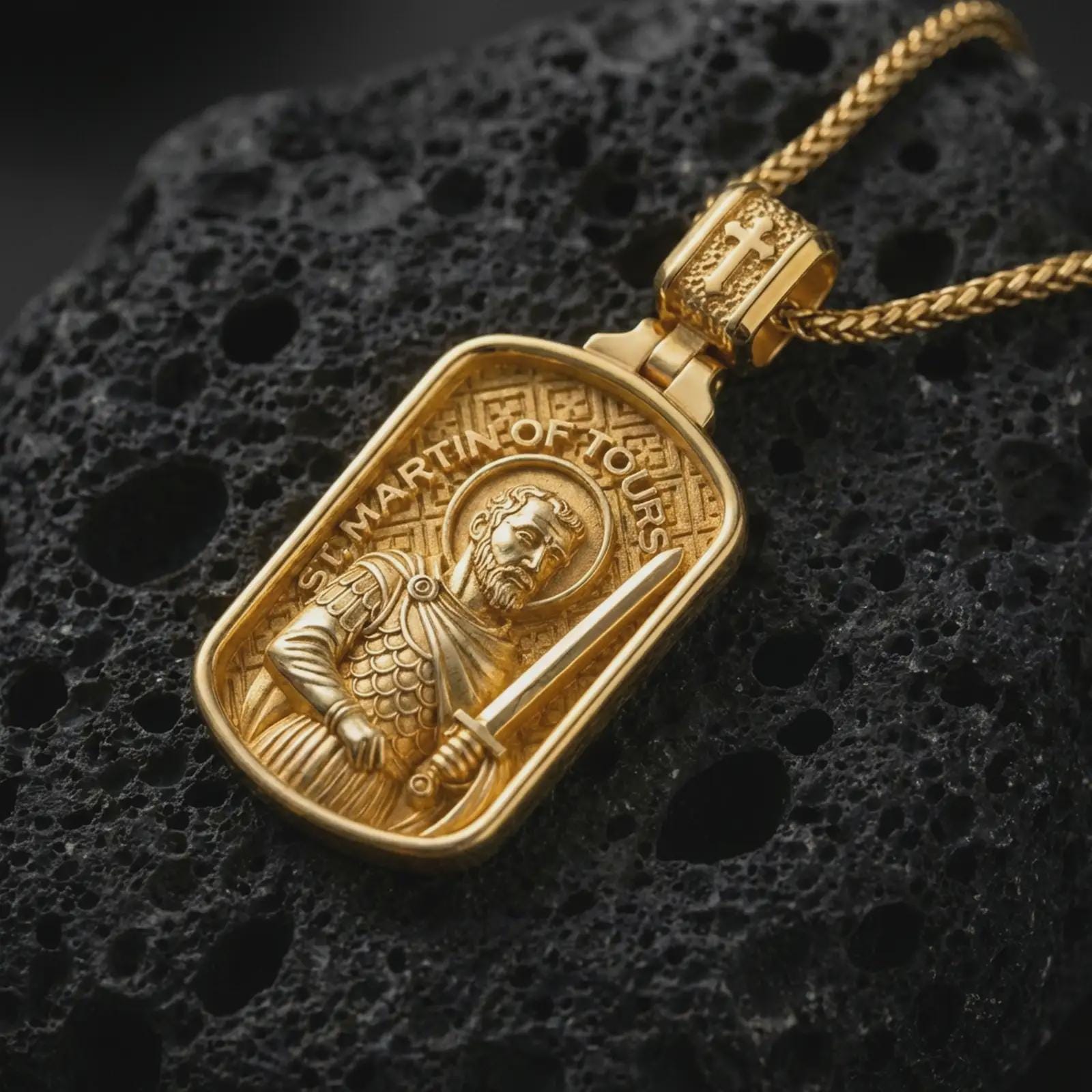 Gold plated Saint Martin of Tours pendant necklace presented on porous volcanic rock, highlighting the rectangular medallion form and sacred devotional design in a luxurious close-up jewelry image.