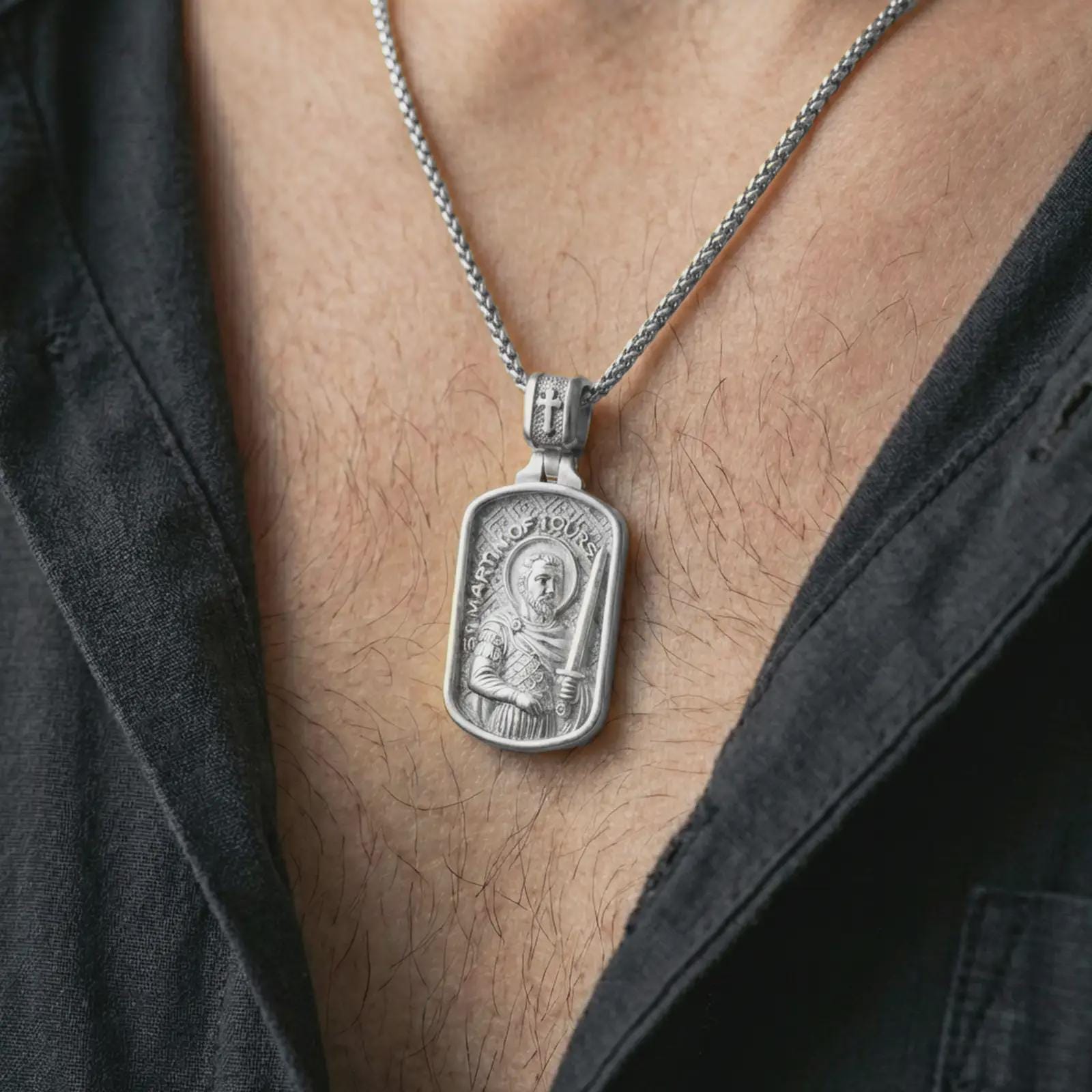 Polished silver Saint Martin of Tours pendant necklace worn on the neck, shown against the chest in a clean and elegant everyday wear composition.
