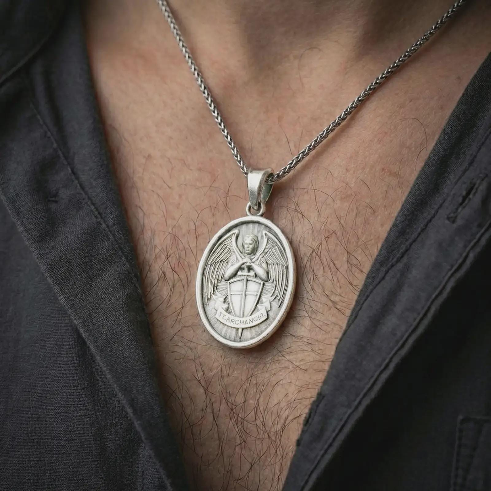 Polished silver Saint Michael Archangel pendant necklace worn on the neck, shown against the chest in a clean and elegant everyday wear composition.