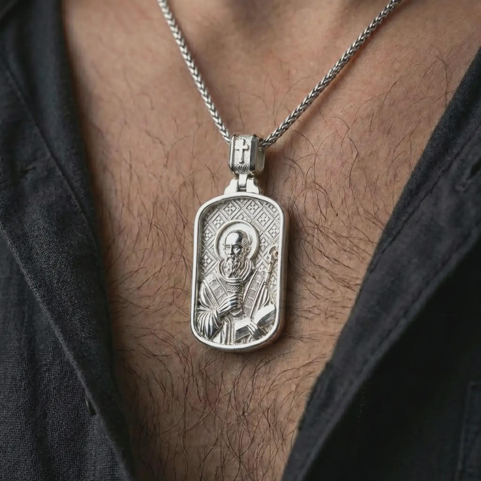 Polished silver Saint Benedict dog tag pendant necklace worn on the neck, shown against the chest in a clean and elegant everyday wear composition.