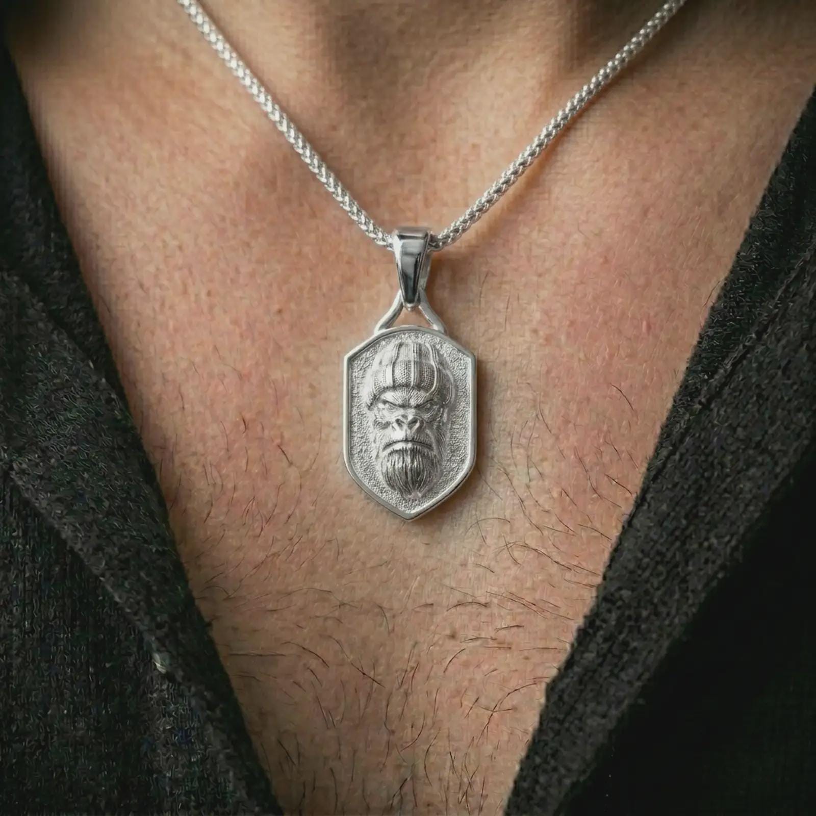 Polished silver gorilla shield pendant necklace worn on the neck, shown against the chest in a clean and striking everyday wear composition.