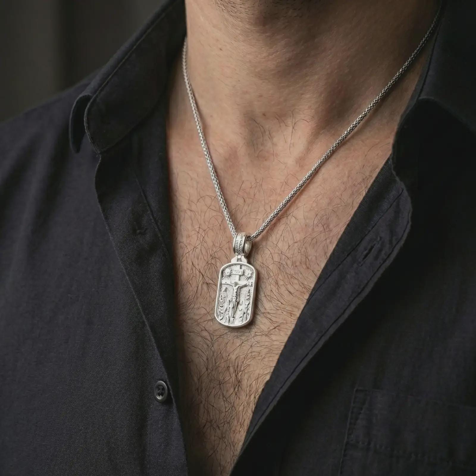 Polished silver Jesus INRI crucifixion pendant necklace worn on the neck, shown against the chest in a clean and elegant everyday wear composition.