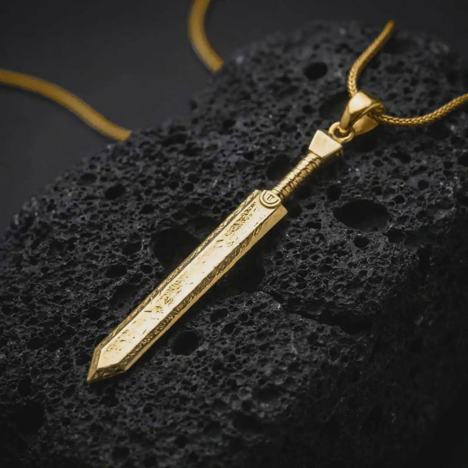 Gold plated Dragonslayer sword pendant necklace presented on porous volcanic rock, highlighting the oversized sword silhouette in a luxurious close-up jewelry image.