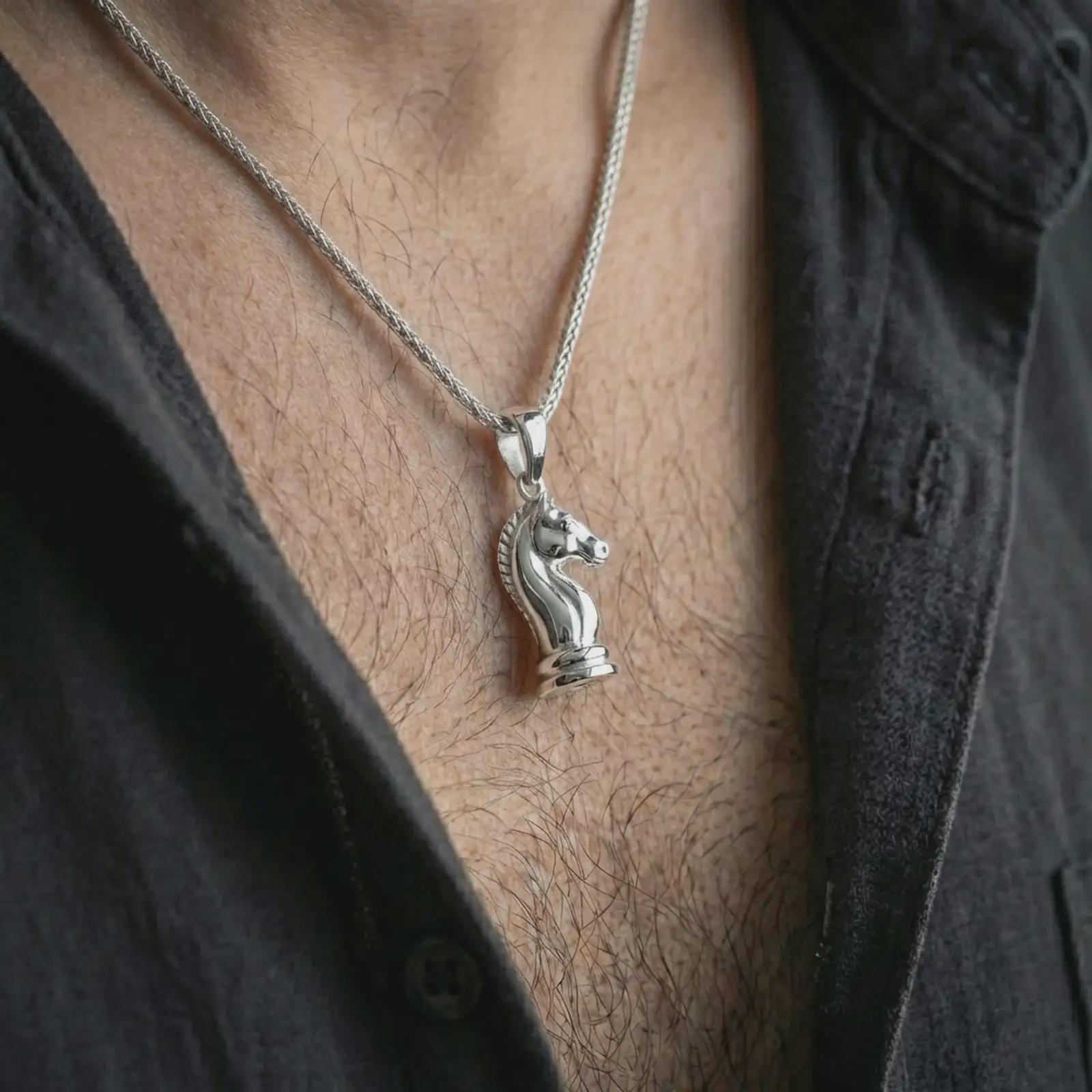 Polished silver knight chess piece pendant necklace worn on the neck, shown against the chest in a clean and striking everyday wear composition.