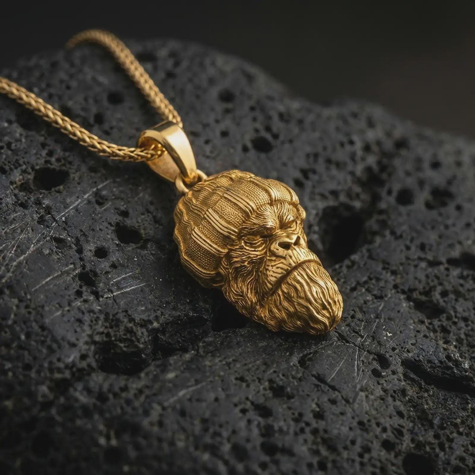 Gold plated gorilla head pendant necklace presented on porous volcanic rock, highlighting the bold street-inspired ape motif in a luxurious close-up jewelry image.