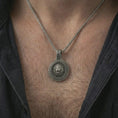 Load image into Gallery viewer, Oxidized Viking lion medallion pendant necklace worn on the neck, styled in a dark lifestyle portrait with an open shirt and bold warrior-inspired presentation.
