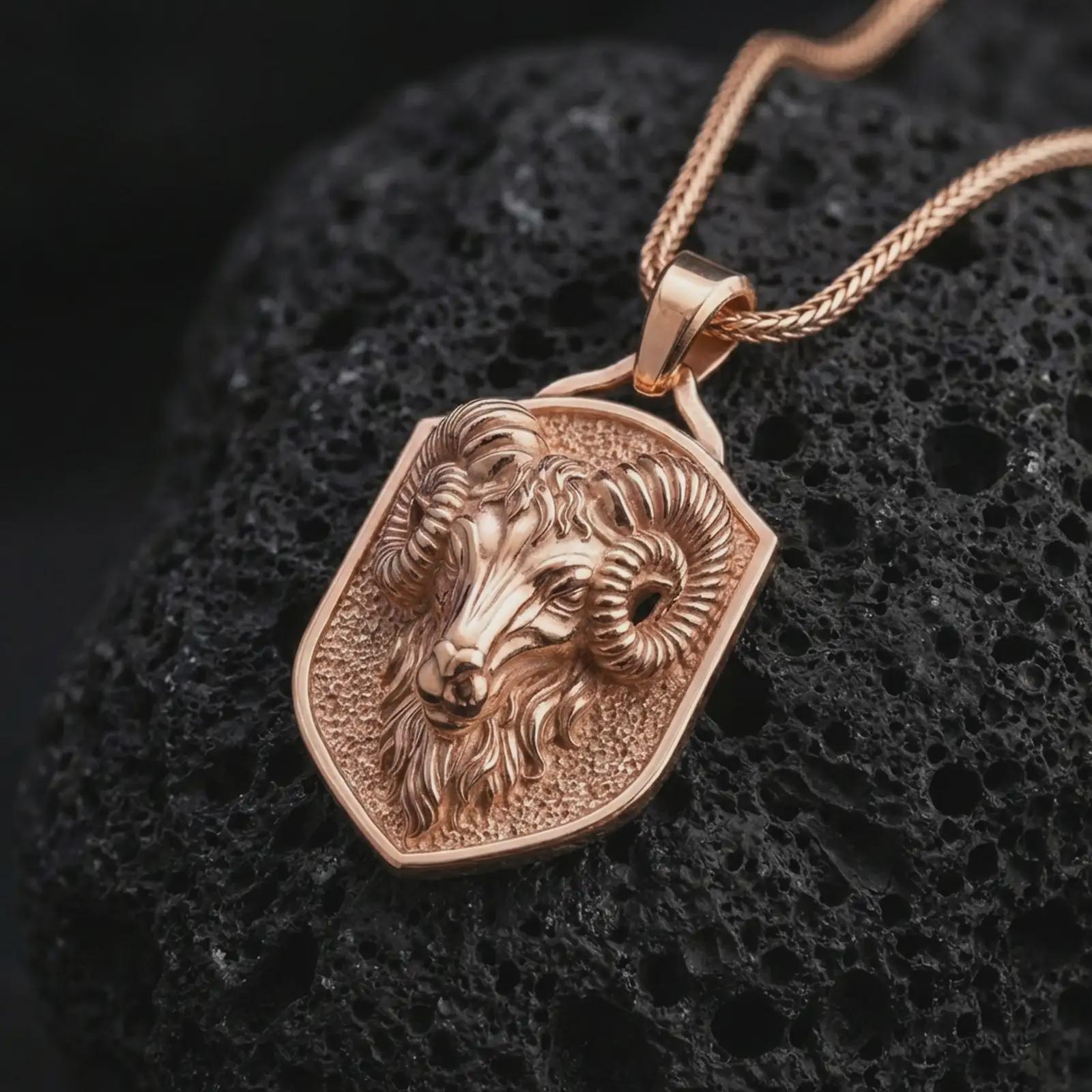 Rose gold plated ram head shield pendant necklace on dark volcanic rock, photographed in a detailed premium studio macro view.
