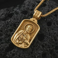 Load image into Gallery viewer, Gold plated Saint Peter dog tag pendant necklace presented on porous volcanic rock, highlighting the rectangular devotional form in a luxurious close-up jewelry image.
