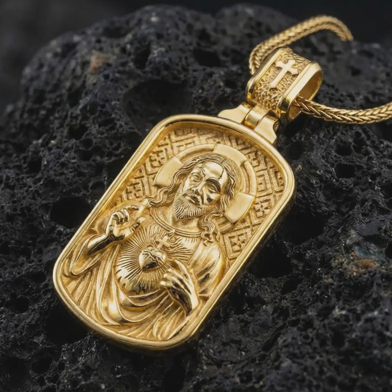 Gold plated Sacred Heart pendant necklace presented on porous volcanic rock, highlighting the rectangular devotional form in a luxurious close-up jewelry image.