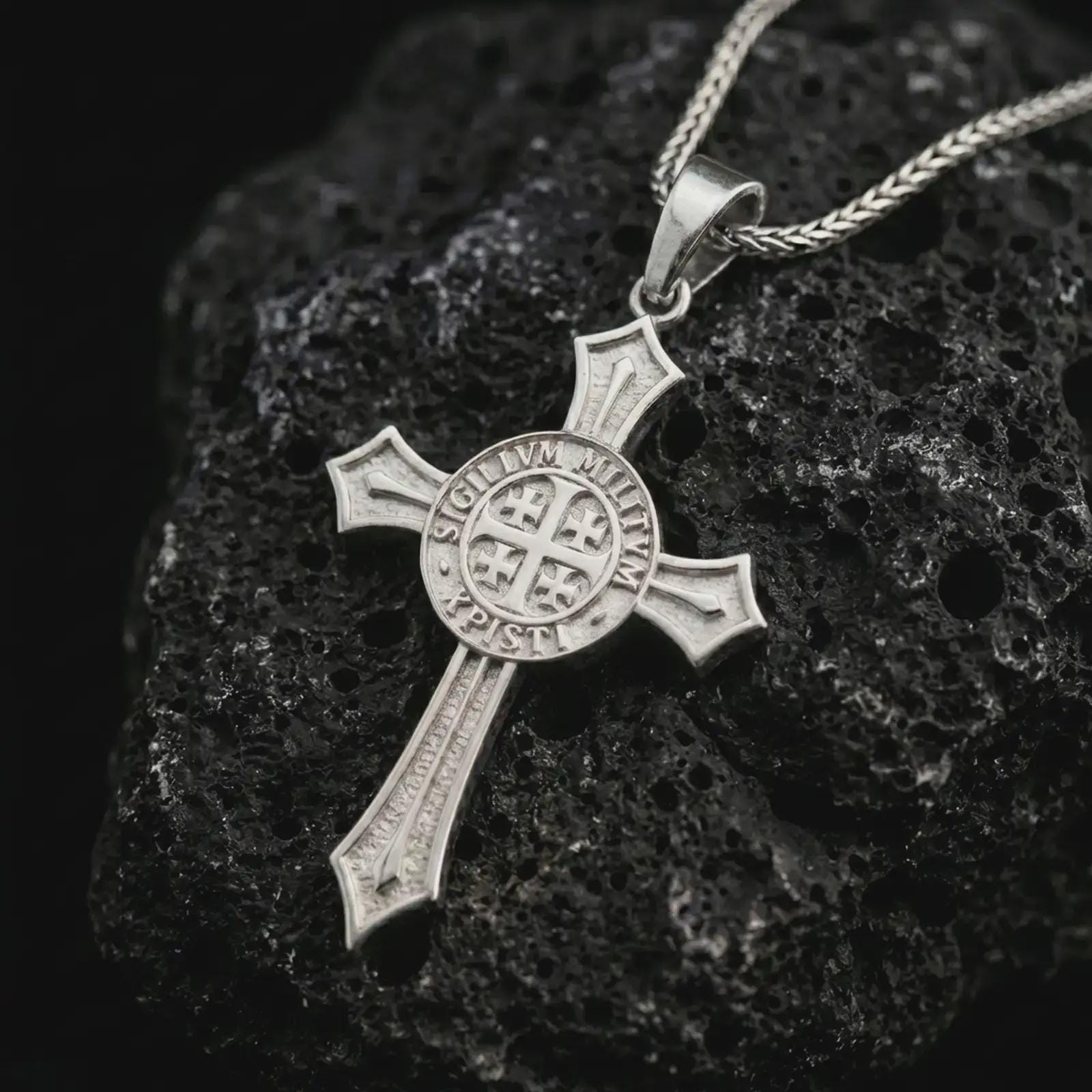 Polished silver Knights Templar cross pendant necklace displayed on black volcanic stone, shown in a premium macro product shot highlighting the medieval crusader cross silhouette and engraved circular seal.