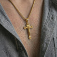Load image into Gallery viewer, Gold plated crucifix pendant necklace worn on the neck, captured in a premium lifestyle composition with the cross pendant centered as a strong spiritual statement.

