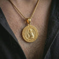 Load image into Gallery viewer, Gold plated Saint Xenia pendant necklace worn on the neck, captured in a premium lifestyle composition with the round saint medal centered as a faith-driven statement.
