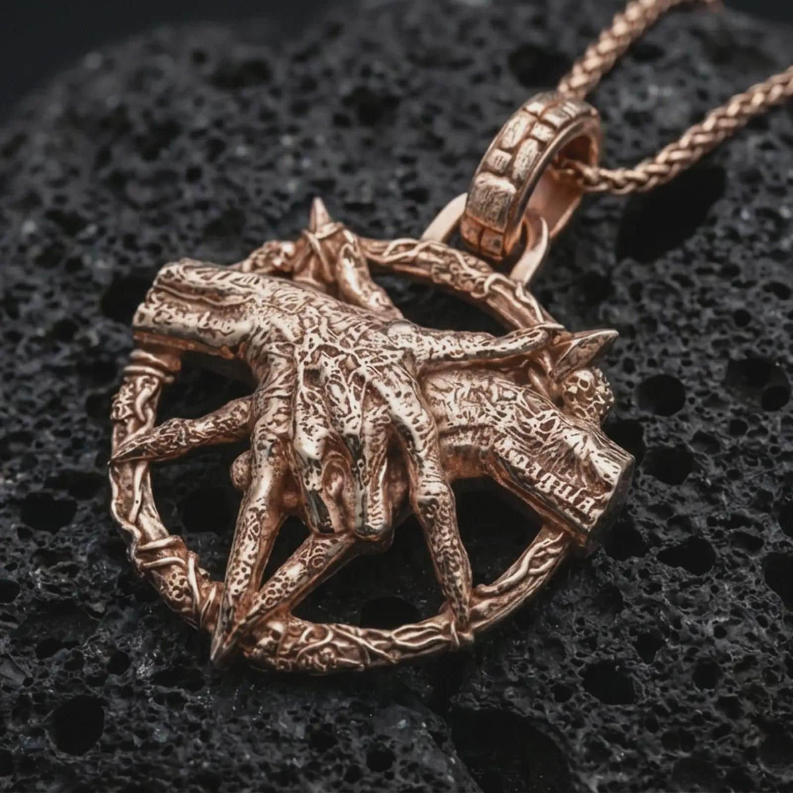 Rose gold plated bad dream catcher pendant necklace on dark volcanic rock, photographed in a detailed premium studio macro view.