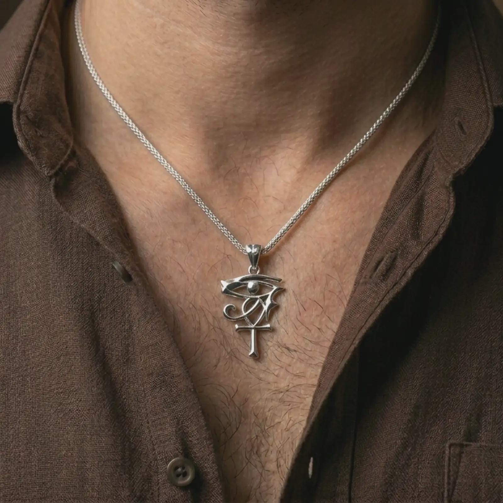 Polished silver Eye of Ra and Ankh pendant necklace worn on the neck, shown against the chest in a clean and elegant everyday wear composition.