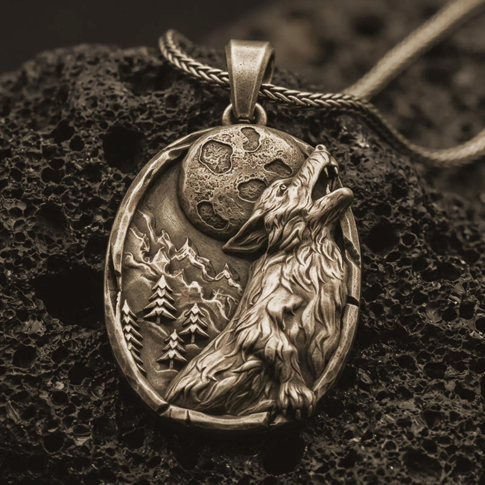 Bronze howling wolf pendant necklace with an oxidized finish resting on textured volcanic rock, captured in a close-up premium studio composition.