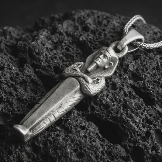 Sterling silver King Tut pendant necklace with an oxidized finish resting on textured volcanic rock, captured in a close-up premium studio composition.