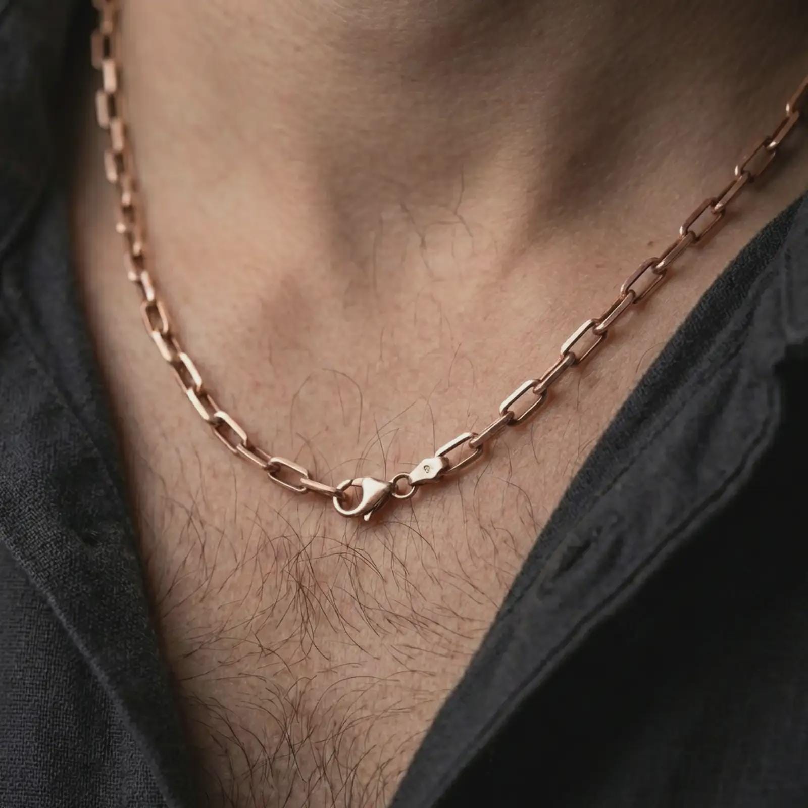 Rose gold plated cable link chain necklace worn on the neck, presented in a close-up lifestyle shot with a refined masculine aesthetic.