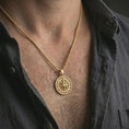 Load image into Gallery viewer, Gold plated compass pendant necklace worn on the neck, captured on a human model in a premium dark-toned lifestyle frame.
