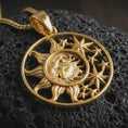 Load image into Gallery viewer, Gold plated sun and moon pendant necklace presented on porous volcanic rock, highlighting the circular cosmic design in a luxurious close-up jewelry image.
