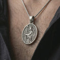 Load image into Gallery viewer, Oxidized Achaemenid soldier pendant necklace worn on the neck, styled in a dark lifestyle portrait that presents the ancient Persian warrior design as a bold historical statement piece.
