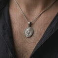 Load image into Gallery viewer, Oxidized Tiberius coin pendant necklace worn on the neck, styled in a dark lifestyle image that presents the ancient Roman emperor medal as a bold historical statement piece.

