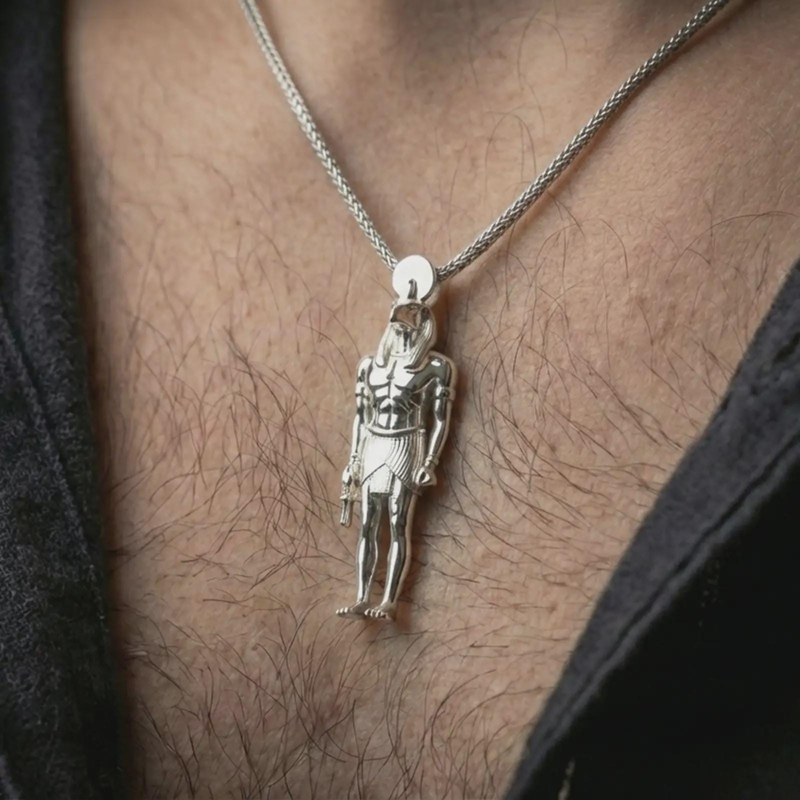 Polished silver Ra amulet pendant necklace worn on the neck, shown in a clean model shot with the ancient Egyptian figure centered for a refined mythology-inspired look.