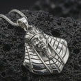 Load image into Gallery viewer, Polished silver Tutankhamun pendant necklace displayed on dark volcanic rock, shown in a premium close-up image that highlights the royal pharaoh face, striped headdress, and ancient Egyptian styling.

