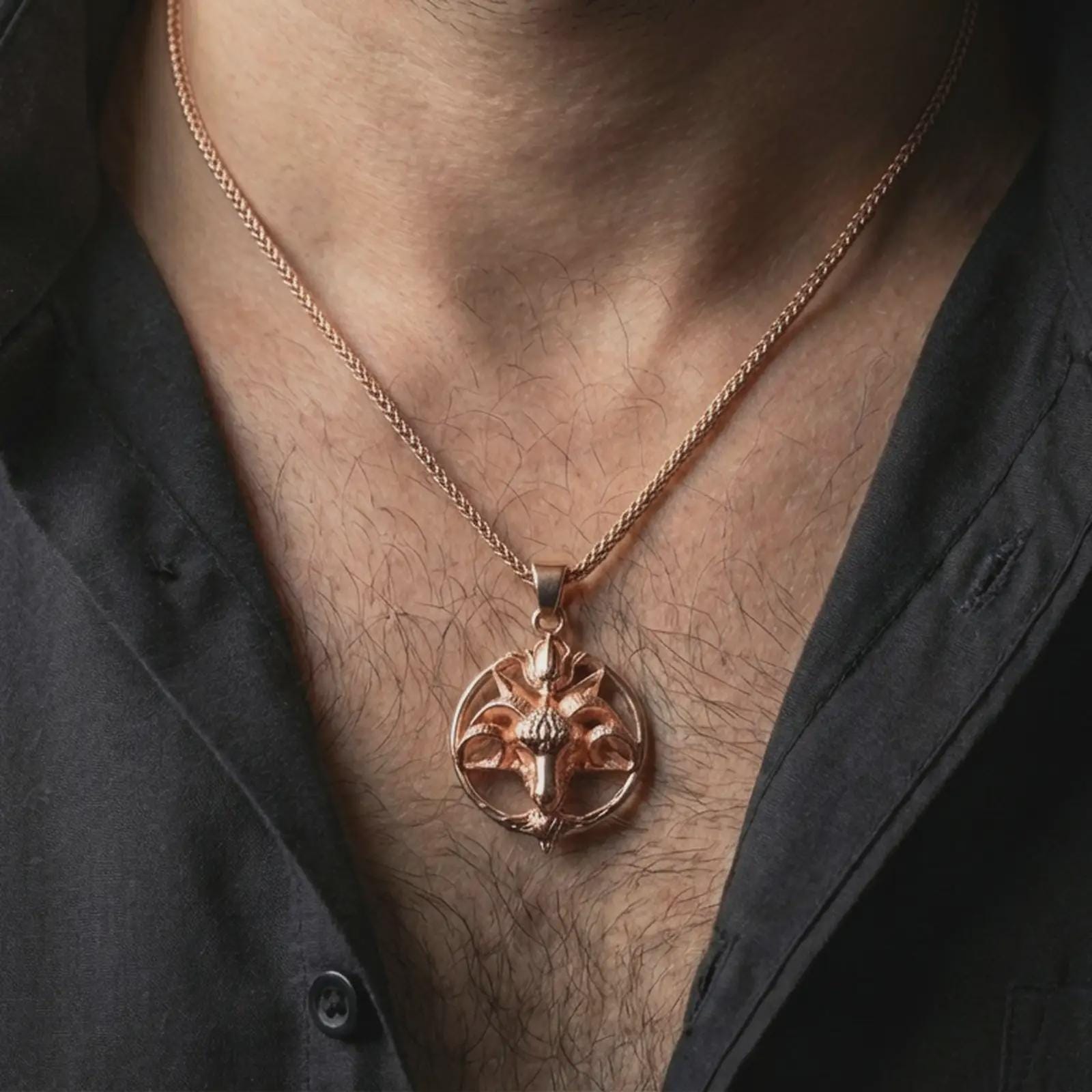 Rose gold plated Baphomet goat head pendant necklace worn on the neck, presented in a close-up lifestyle shot with a refined masculine aesthetic.